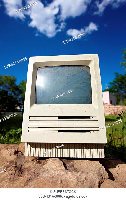 An Apple Macintosh SE computer, produced between 1987 and 1990, sits atop a rock in a suburban part of Fort Collins, Colorado