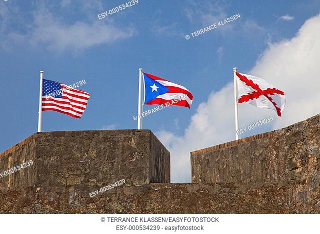 The flags of the United States, Puerto Rico and the Spanish Cross of Burgundy fly over the walls of the San Cristobal Castle in San Juan, Puerto Rico