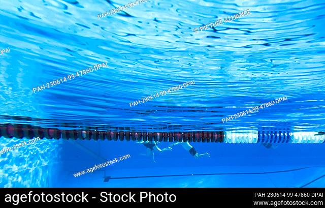 14 June 2023, Lower Saxony, Hanover: Early morning swimmers do their laps in the outdoor pool Annabad. Photo: Julian Stratenschulte/dpa