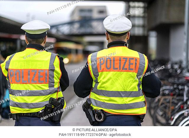 06 November 2019, Baden-Wuerttemberg, Freiburg: Two federal police officers are standing at the main station and watching buses entering the bus station