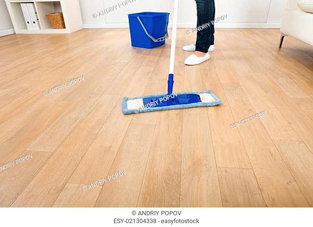 Woman Mopping Hardwood Floor At Home
