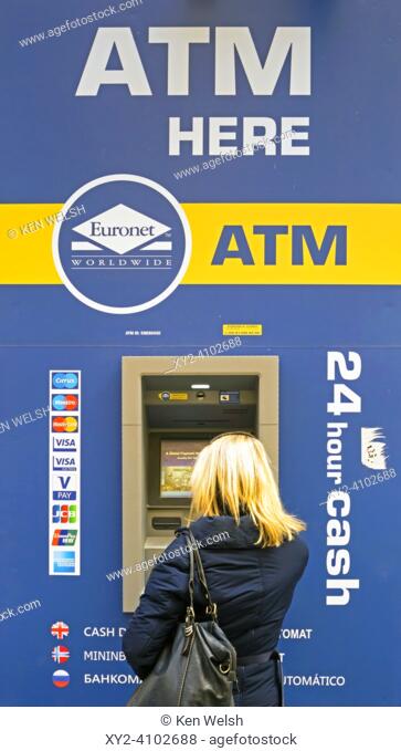 Woman withdrawing money from an ATM cash point in Cordoba, Cordoba Province, Andalusia, Spain. ATM, Automated Teller Machine
