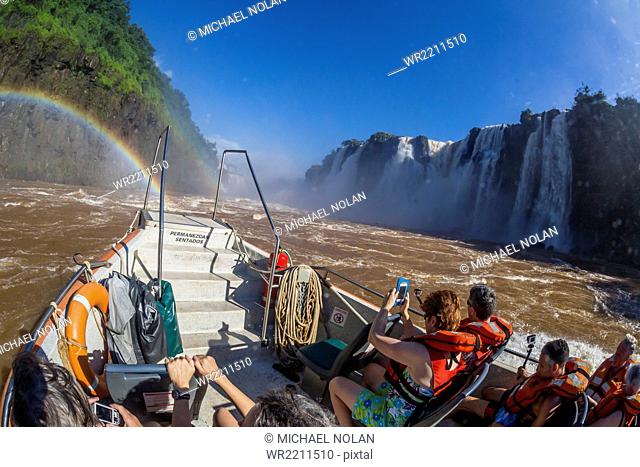 Tourists take a river boat to the base of the falls, Iguazu Falls National Park, UNESCO World Heritage Site, Misiones, Argentina, South America