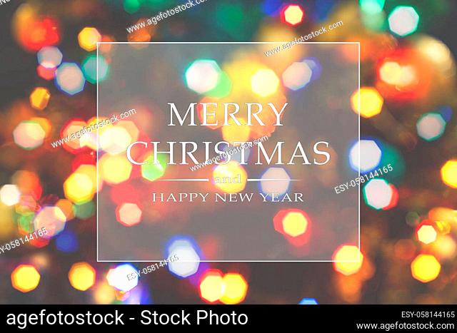 Merry Christmas and Happy New Year greeting card, blurred background of the twinkling lights of the Christmas tree. Greeting card background