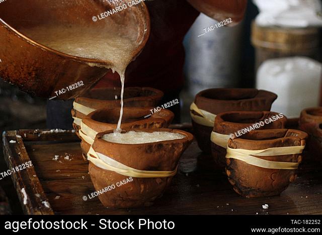 MEXICO CITY, MEXICO - OCTOBER 23: A person pours a mixture of sugar with water into a clay mold in the shape of a skull during the making of the traditional...