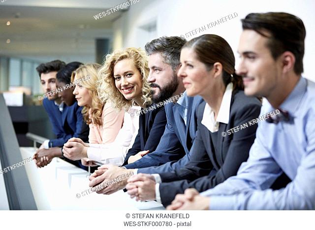 Germany, Neuss, Group of business people, leaning on railing