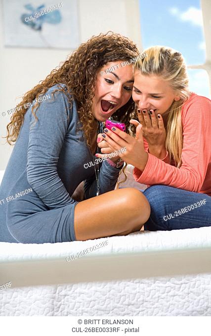 Girlfriends laugh at cell phone text