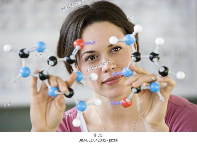 Hispanic woman holding molecular model