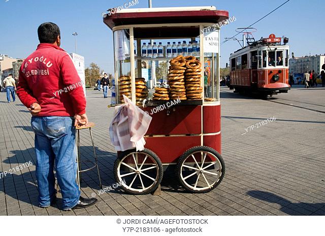 Simit sesame bread rings for sale and the old tram in Taksim Square , Istanbul, Turkey, Middle East