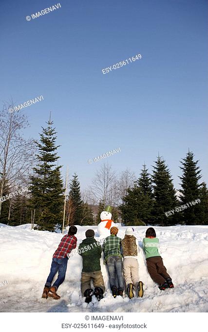 Young people looking at snowman