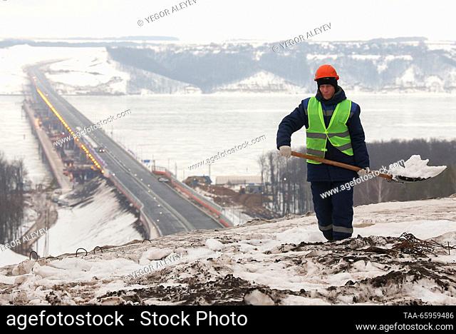 RUSSIA, REPUBLIC OF TATARSTAN - DECEMBER 21, 2023: A worker shovels snow by M12 Highway as it opens to traffic. The distance of 810km from Moscow to Kazan can...