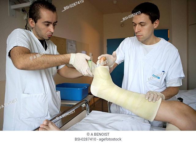 Photo essay from La Croix Saint-Simon Hospital, Paris, France. Department of orthopedics. Placement of a resin plaster by the physical therapists on a fractured...