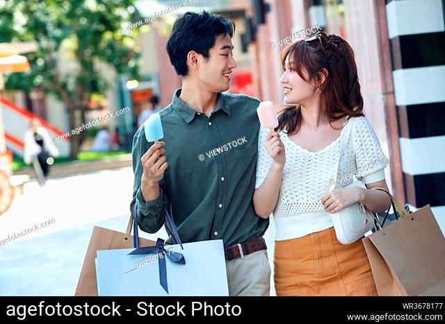 Happy couples go shopping to eat popsicles