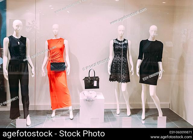 Four Mannequins Standing In Store Window Display Of Women's Casual Clothing Shop In Shopping Mall