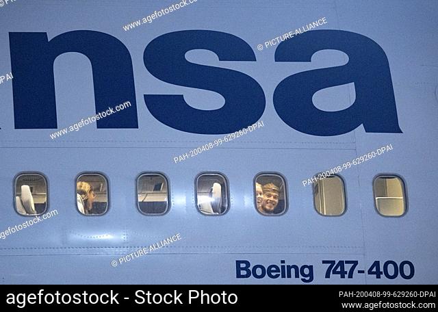 dpatop - 08 April 2020, Hessen, Frankfurt/Main: Passengers wait in the cabin of a Boeing 747 of Lufthansa after landing at Frankfurt Airport to be allowed to...