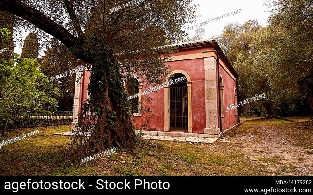 Greece, Greek Islands, Ionian Islands, Corfu, Corfu Town, Park Von Repos, dusky pink colored building in the park, in front of it a tree