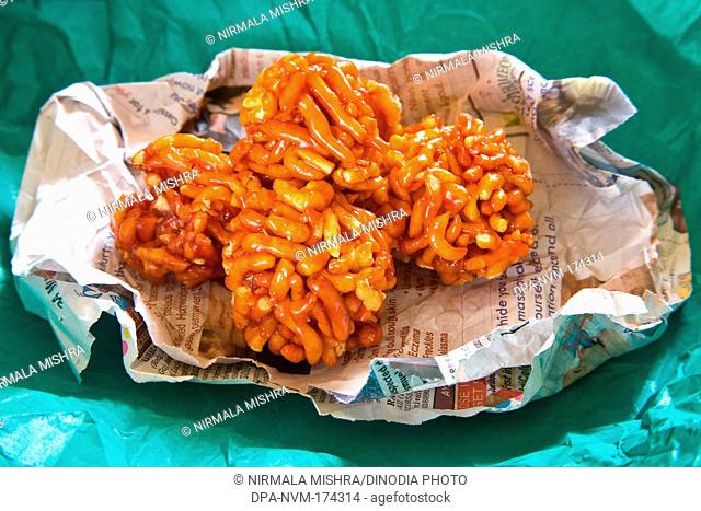 Indian mithai ladoo of gathia and jaggery on newspaper and green wrapper 20-April-2010