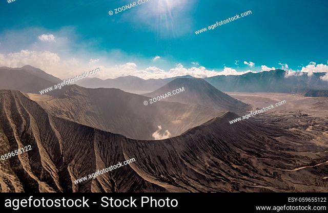 Cinematic shot aerial view of Mount Bromo crater with active volcano smoke in East Java, Indonesia