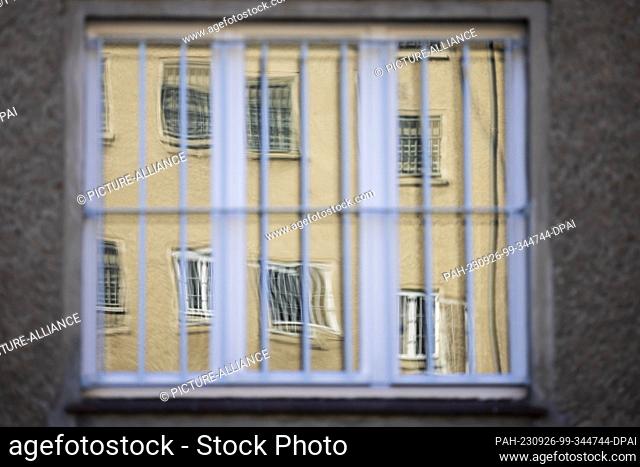 26 September 2023, Berlin: Barred windows are reflected in an equally barred window of the Hohenschönhausen Memorial. Photo: Christoph Soeder/dpa