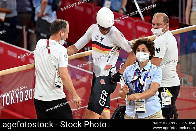 07 August 2021, Japan, Izu: Cycling/Track: Olympics, Madison, Men at Izu Velodrome. Roger Kluge from Germany looks at his wounds after a crash