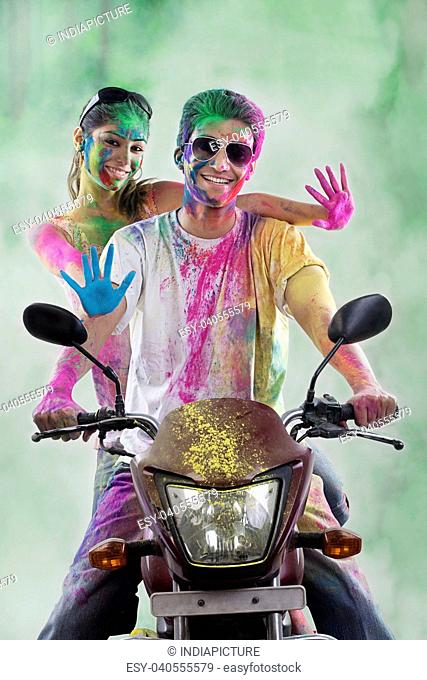 Couple on a motorcycle covered with colours