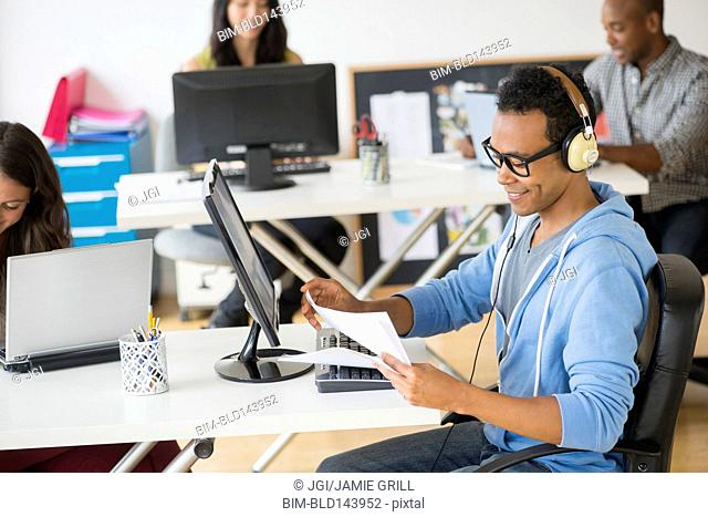 Businessman listening to headphones and working in office