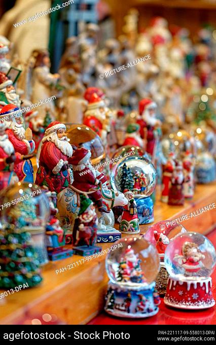 17 November 2022, North Rhine-Westphalia, Cologne: Santa Claus figures stand in a booth at the Christmas market in front of Cologne Cathedral