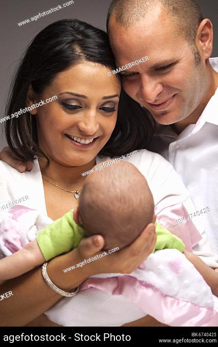 Happy young attractive mixed-race family with newborn baby
