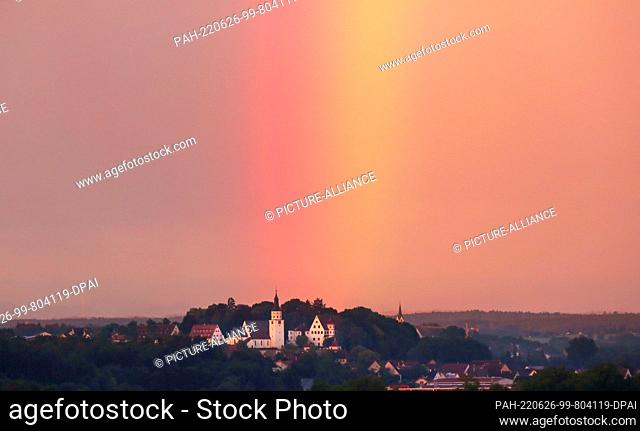 26 June 2022, Baden-Wuerttemberg, Riedlingen: While Neufra Castle near Riedlingen and the church of St. Peter and Paul are illuminated by the rising sun