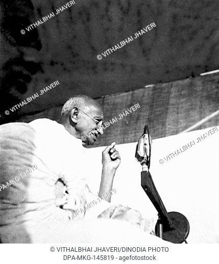 Mahatma Gandhi speaking into a mike at a mass meeting in Bengal , 1945 NO MR