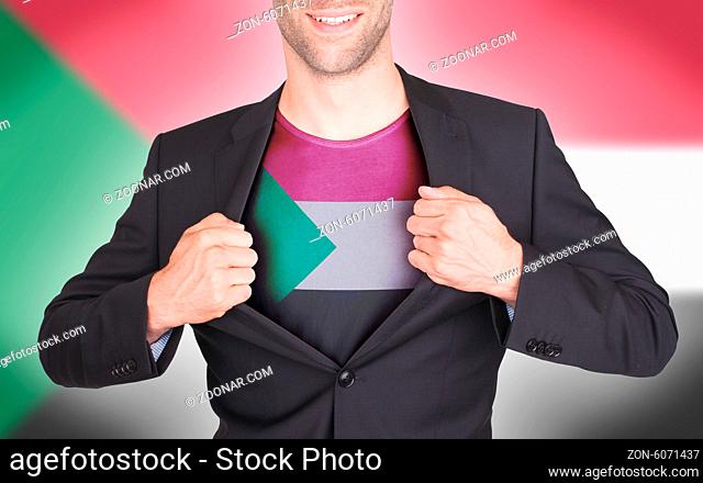 Businessman opening suit to reveal shirt with flag, Sudan