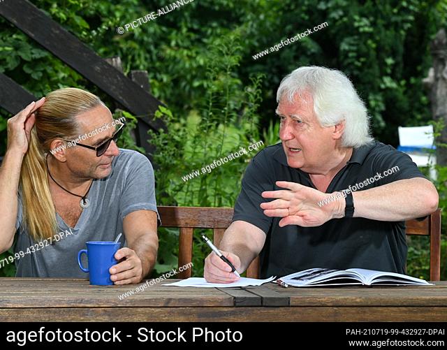 16 July 2021, Brandenburg, Hoppegarten: Silly guitarist Uwe Hassbecker (l) and music expert Wolfgang Martin discuss the new book ""Paradiesvögel fängt man nicht...
