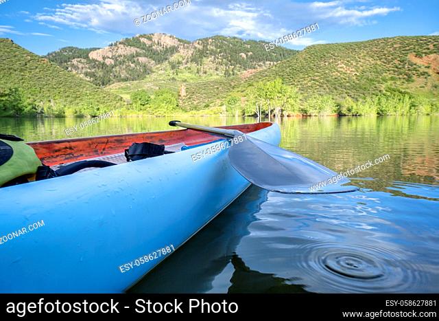 stand up paddleboard with a paddle on a calm mountain lake - Horsetooth Reservoir in northern Colorado, early summer morning scenery