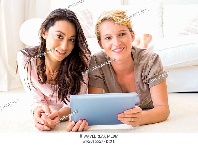 Portrait of smiling homosexual couple using tablet computer together