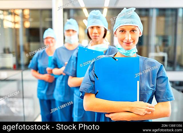 Chirurgen Team mit junger Ärztin oder Krankenschwester in blauer OP-Kleidung