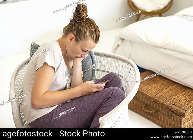 teenage girl using smart phone in her bedroom