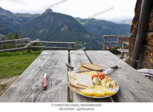 Snack at a picnic table in the Grossellmaualm alpine pasture, Grossarltal, Salzburg, Austria, Europe