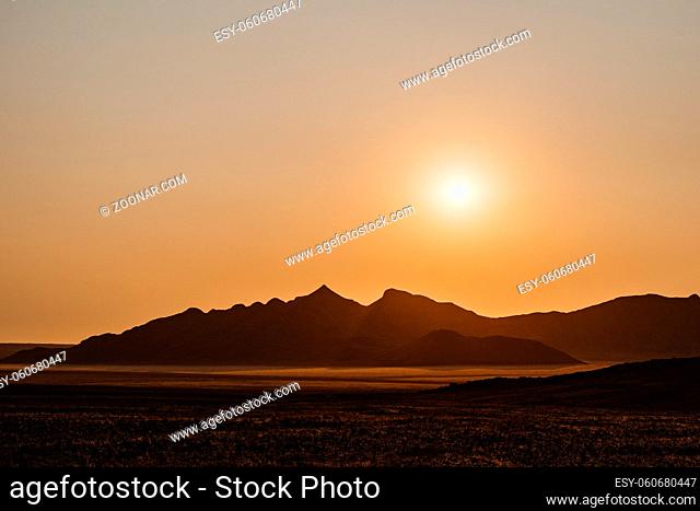 mesmeringing sunset at NamibRand Naturreservat with mountains and desert sand in Namibia, Africa