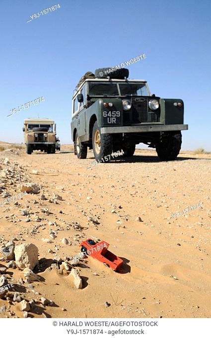 Africa, Tunisia, nr  Ksar Rhilane  Historic Land Rovers including a toy car on a desert trip