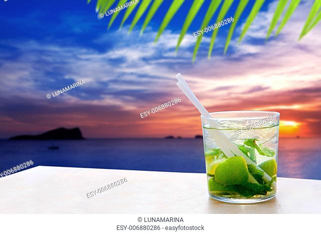 Ibiza cala Conta Conmte sunset with Mojito drink cocktail