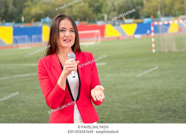 Pretty journalist is reporting from the stadium for television