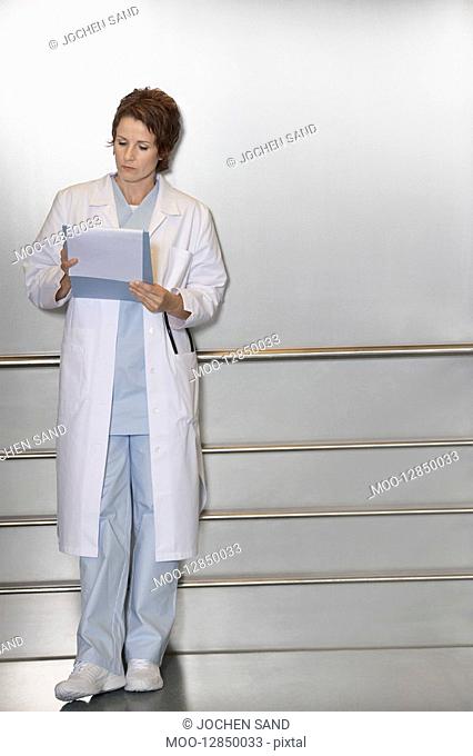 Physician Reviewing Notes in elevator