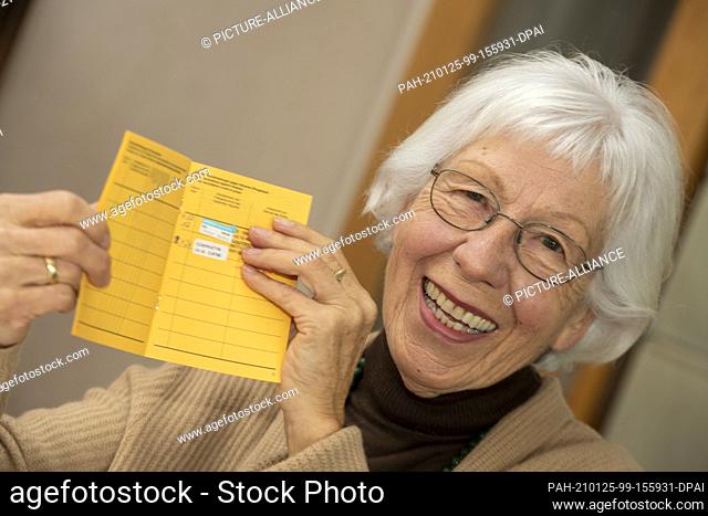 23 January 2021, Baden-Wuerttemberg, Ulm: Senior Ursula Neuberger holds her vaccination certificate, which includes a flu shot (above) and her first Corona...