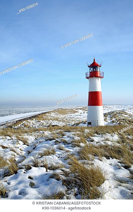 Lighthouse List East on snow covered dunes with a bright blue sky at a sunny day with icy sea in the background, Sylt, Northfrisian Islands, Schleswig-Holstein