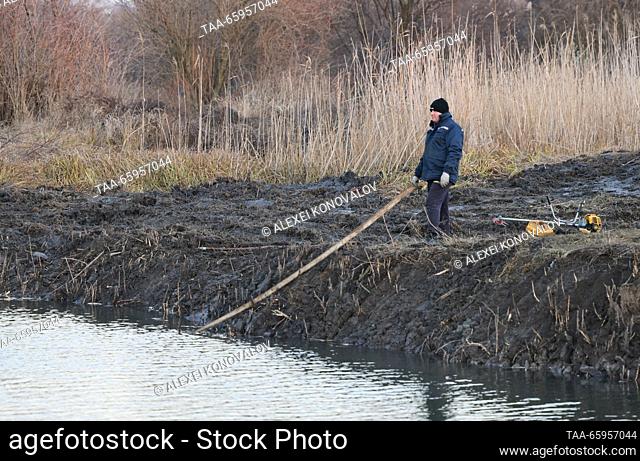 RUSSIA, KHERSON REGION - DECEMBER 20, 2023: A man cleans up a bank of the Kalanchak River. Alexei Konovalov/TASS