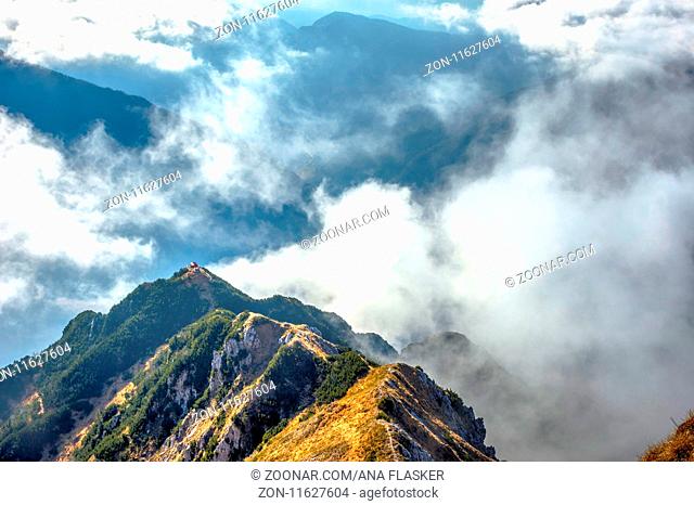 Via ferrata over the sea of clouds to bivouac Dino above Udine. The Alps, Italy