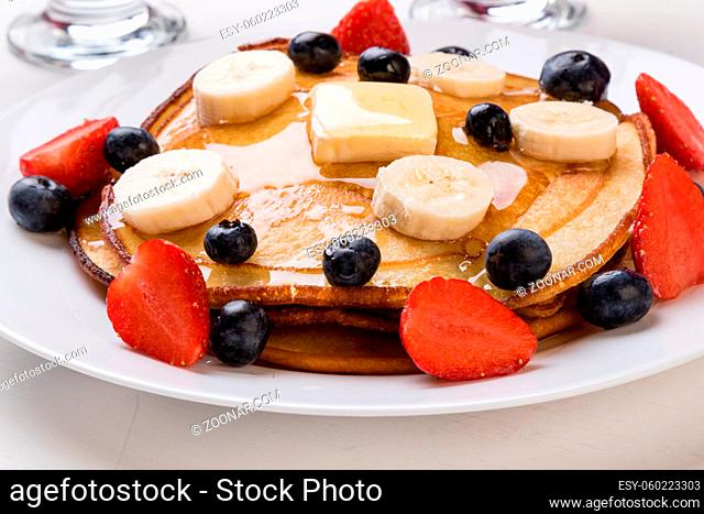 pancakes with blueberry, banana, strawberry and syrup