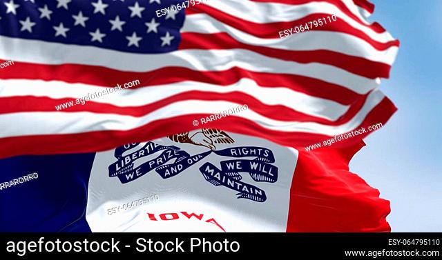 Close-up of Iowa state flag waving in the wind with the American national flag on a clear day. 3d illustration render. Rippled fabric. Selective focus