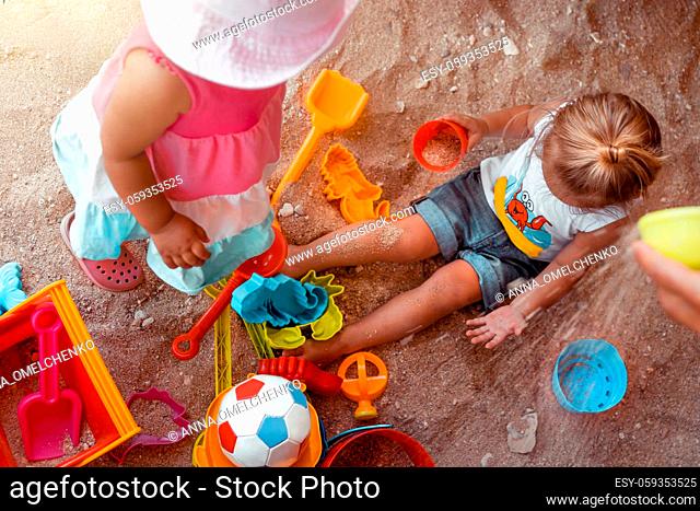 Two Happy Little Kids Playing with Different Colorful Toys in Sandbox. With Pleasure Spending Summer Holidays on the Beach. Enjoying Childhood