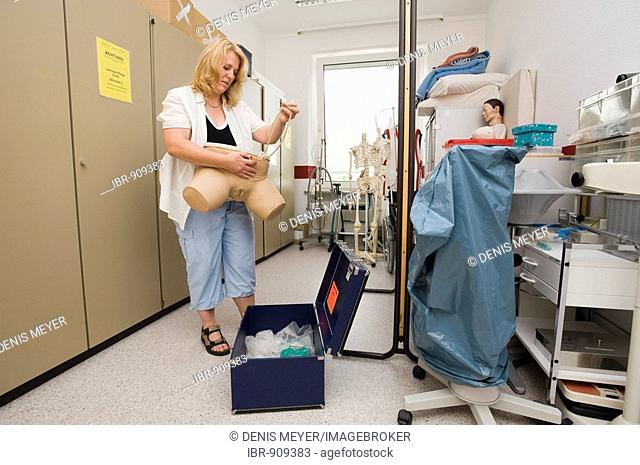 Geriatric care trainer prepares a dummy for catheter training in the teaching aid storeroom